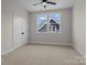 Bright bedroom features neutral carpet, a ceiling fan, and double windows offering natural light at 119 Mills Garden Rd, Statesville, NC 28625
