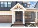 Inviting front porch with wooden deck, white columns, and a modern front door at 119 Mills Garden Rd, Statesville, NC 28625
