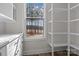 Walk-in pantry with white shelving and cabinets, and natural light through the window at 119 Mills Garden Rd, Statesville, NC 28625