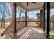 Outdoor porch with wood flooring, dark stained columns and wood railing overlooking backyard at 119 Mills Garden Rd, Statesville, NC 28625