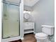 Neutral colored bathroom featuring a shower, toilet, vanity with a round mirror, and wood-look floors at 126 Anchor Ln, Troutman, NC 28166