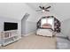 Slanted ceiling bedroom featuring a television on a dresser, floral wallpaper, and a comfortable seating area at 126 Anchor Ln, Troutman, NC 28166
