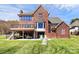 Back exterior view of a well-maintained red brick home with a patio and a deck at 126 Anchor Ln, Troutman, NC 28166