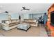 Open-concept living room with a large sectional sofa, an ottoman, a ceiling fan, and neutral-colored walls at 126 Anchor Ln, Troutman, NC 28166