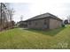 Home's backyard showcasing a brick exterior, well-manicured lawn, and fencing at 12889 Hill Pine Rd, Midland, NC 28107