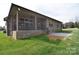 Home's backyard showcasing a brick exterior, well-manicured lawn, and covered patio space at 12889 Hill Pine Rd, Midland, NC 28107