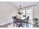 Elegant dining area featuring a modern chandelier, natural light, and a stylish round, decorative clock at 12889 Hill Pine Rd, Midland, NC 28107