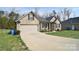 Charming single-story home featuring a 2-car garage, well-manicured lawn and inviting covered porch at 12889 Hill Pine Rd, Midland, NC 28107