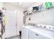 Well-equipped laundry room with washer, dryer, storage shelves, and a door leading to the outside at 12889 Hill Pine Rd, Midland, NC 28107