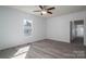 Bright bedroom with hardwood floors, a ceiling fan, white walls, and a window overlooking the neighborhood at 1411 Roseland Dr, Lincolnton, NC 28092