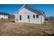 Rear view of the home, featuring vinyl siding, a single door, and a well-manicured lawn at 1411 Roseland Dr, Lincolnton, NC 28092