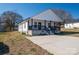 Charming home with a black front porch, white vinyl siding, a gray sidewalk, and a well-maintained lawn at 1411 Roseland Dr, Lincolnton, NC 28092