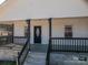Inviting front porch with black railings and support beams frames a decorative front door at 1411 Roseland Dr, Lincolnton, NC 28092