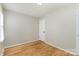 Bedroom features hardwood floors, light walls, and a white paneled door at 1438 Plumstead Rd, Charlotte, NC 28216