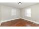 This bedroom features lustrous hardwood floors and natural light from two windows at 1438 Plumstead Rd, Charlotte, NC 28216