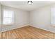 Bedroom features hardwood floors, light walls, and two windows with blinds at 1438 Plumstead Rd, Charlotte, NC 28216