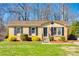 Charming one-story brick home featuring a well-manicured lawn and complementing shrubs at 1438 Plumstead Rd, Charlotte, NC 28216