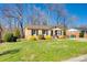 This beautiful home boasts lush green grass, manicured shrubs, and mature trees at 1438 Plumstead Rd, Charlotte, NC 28216