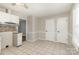 View of kitchen eating area with white cabinets, tile flooring, and two white paneled doors at 1438 Plumstead Rd, Charlotte, NC 28216