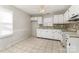 Kitchen features white cabinetry, tile backsplash, tile flooring, and a window at 1438 Plumstead Rd, Charlotte, NC 28216