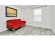 Bedroom features gray floors, natural light from the window, and a red futon couch at 16138 Aryshire Green Ct, Charlotte, NC 28273