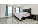 This bedroom features a large bed with grey wood flooring, a large mirror, and natural light from the windows at 16138 Aryshire Green Ct, Charlotte, NC 28273