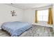 This bedroom features a bed, grey wood flooring, a window and yellow curtains at 16138 Aryshire Green Ct, Charlotte, NC 28273