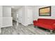 Hallway features a red futon couch, gray flooring, and neutral paint at 16138 Aryshire Green Ct, Charlotte, NC 28273