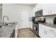 Modern kitchen with stainless steel appliances, granite counters, and sleek white cabinetry at 16138 Aryshire Green Ct, Charlotte, NC 28273
