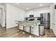Bright kitchen features a center island with barstool seating, stainless steel appliances, and white cabinetry at 16138 Aryshire Green Ct, Charlotte, NC 28273