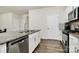 Modern kitchen showcasing a center island, stainless steel dishwasher, and sleek white cabinetry at 16138 Aryshire Green Ct, Charlotte, NC 28273