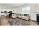 Open-concept living room with hardwood floors, a cozy fireplace, and access to the kitchen at 16138 Aryshire Green Ct, Charlotte, NC 28273