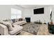 Spacious living room showcasing a fireplace, a large sectional, and hardwood floors at 16138 Aryshire Green Ct, Charlotte, NC 28273