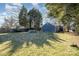 View of spacious backyard with large shade trees and fenced perimeter, perfect for recreation at 2137 Highland St, Charlotte, NC 28208