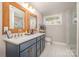 Bathroom featuring double sinks, wood framed mirrors, granite countertop, and tiled floors at 2137 Highland St, Charlotte, NC 28208