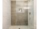 Modern tiled shower featuring glass door, bronze fixtures, shampoo niche, and mosaic tile shower floor at 2137 Highland St, Charlotte, NC 28208