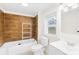 Bathroom with wood-style tiled walls, combination shower-tub, and modern sink at 216 Blackwelder St, Kannapolis, NC 28081