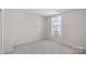 Well-lit bedroom with neutral carpet and natural light from one window at 2462 Willow Pond Se Ln, Concord, NC 28025
