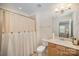 Well-lit bathroom with tile floors, wooden vanity and shower with curtain at 4018 Moxie Way, Charlotte, NC 28215