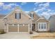 Charming brick and siding home featuring a well-manicured lawn and an attached two-car garage at 4018 Moxie Way, Charlotte, NC 28215