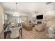 Spacious open-concept living area featuring a fireplace, built-in shelves, and large dining table at 4018 Moxie Way, Charlotte, NC 28215