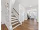 Elegant foyer features hardwood floors, staircase, and stylish light fixtures, creating a warm welcome at 4039 Highgate Ln, Lancaster, SC 29720