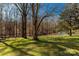 Large backyard with a shed, surrounded by mature trees on a sunny day at 4919 Rehobeth Rd, Waxhaw, NC 28173