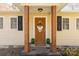 Inviting front entryway features a stained door, wooden pillars, and a cozy welcome mat at 4919 Rehobeth Rd, Waxhaw, NC 28173