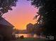 Picturesque sunset view overlooking a serene pond, with a glimpse of the golf course in the background at 522 Sarazen Way, Salisbury, NC 28144