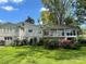 Large backyard featuring a patio, balcony, and beautiful garden with blooming azaleas and lush green grass at 536 S Union S St, Concord, NC 28025