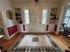 Inviting foyer with built-in shelves, hardwood floors, and a classic rug leading to the front door at 536 S Union S St, Concord, NC 28025