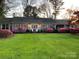 Charming home featuring a well-manicured lawn and vibrant pink azalea bushes lining the front at 536 S Union S St, Concord, NC 28025