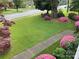 Lush front yard featuring manicured lawn, flowering bushes, and mature trees, enhancing curb appeal at 536 S Union S St, Concord, NC 28025
