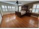 Spacious main bedroom featuring hardwood floors, a ceiling fan, and many windows at 536 S Union S St, Concord, NC 28025